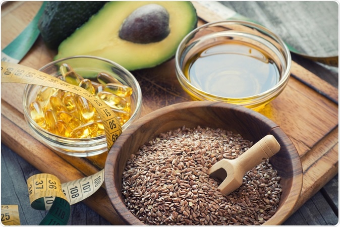 Sources of omega 3 fatty acids: flaxseeds, avocado, oil capsules and flaxseed oil. Image Credit: Lecic / Shutterstock