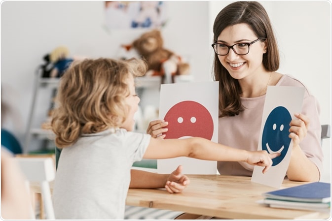 Emotion emoticons used by a psychologist during a therapy session with a child with an autism spectrum disorder. Image Credit: By Photographee.eu / Shutterstock