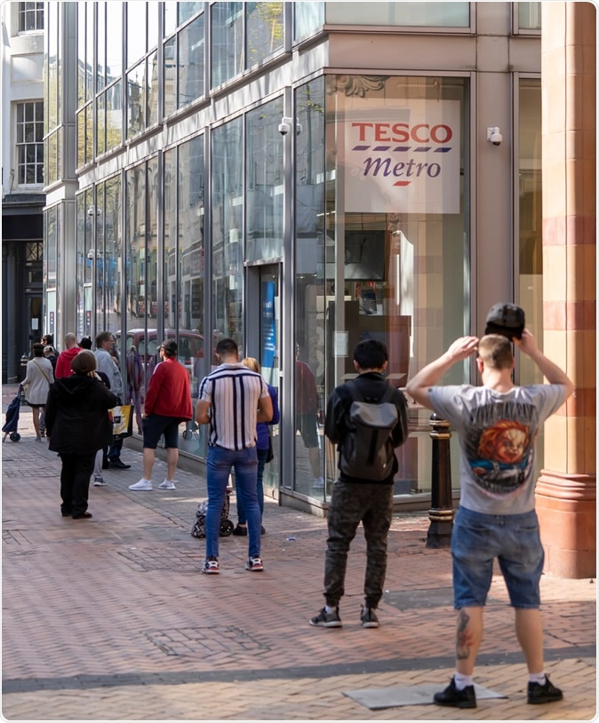 BIRMINGHAM, UK - 2020: Queue of people social distancing at supermarket in Birmingham city centre during coronavirus pandemic. Image Credit: UAV 4 / Shutterstock
