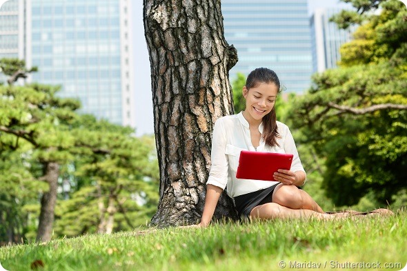 Asian business woman reading using tablet app in Tokyo