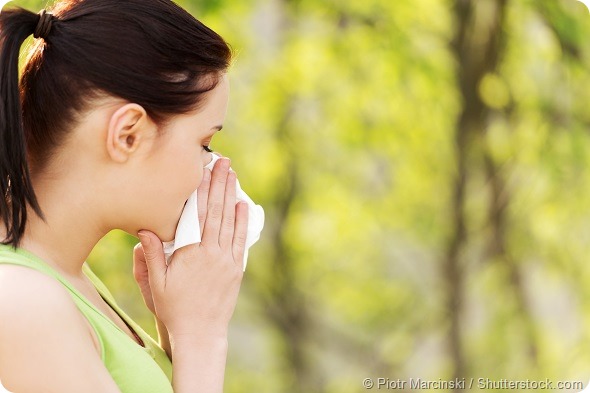 Attractive woman outdoor with tissue having allergy