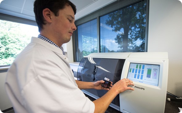 Lab-technician-inserts-tissue-slide-rack-into-the-Philips-IntelliSite-ul... tissue slide rack