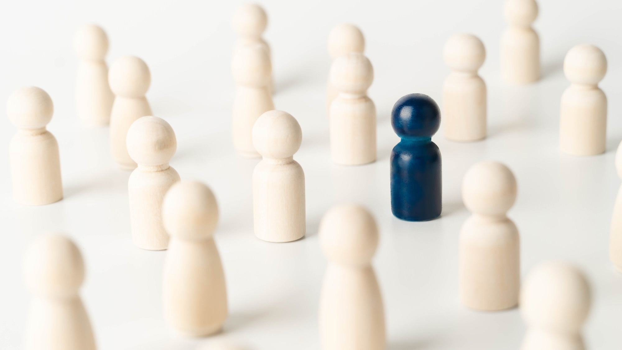 Wooden figures of people, one of them is blue.