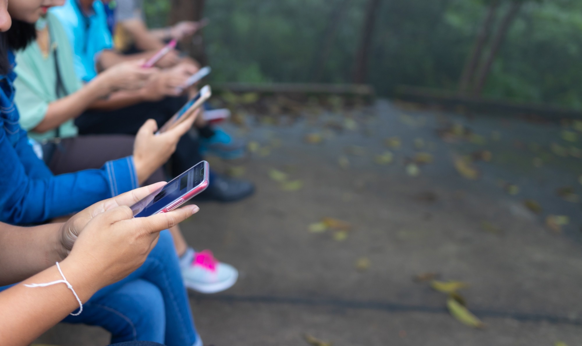 Group of friends watching smart mobile phones