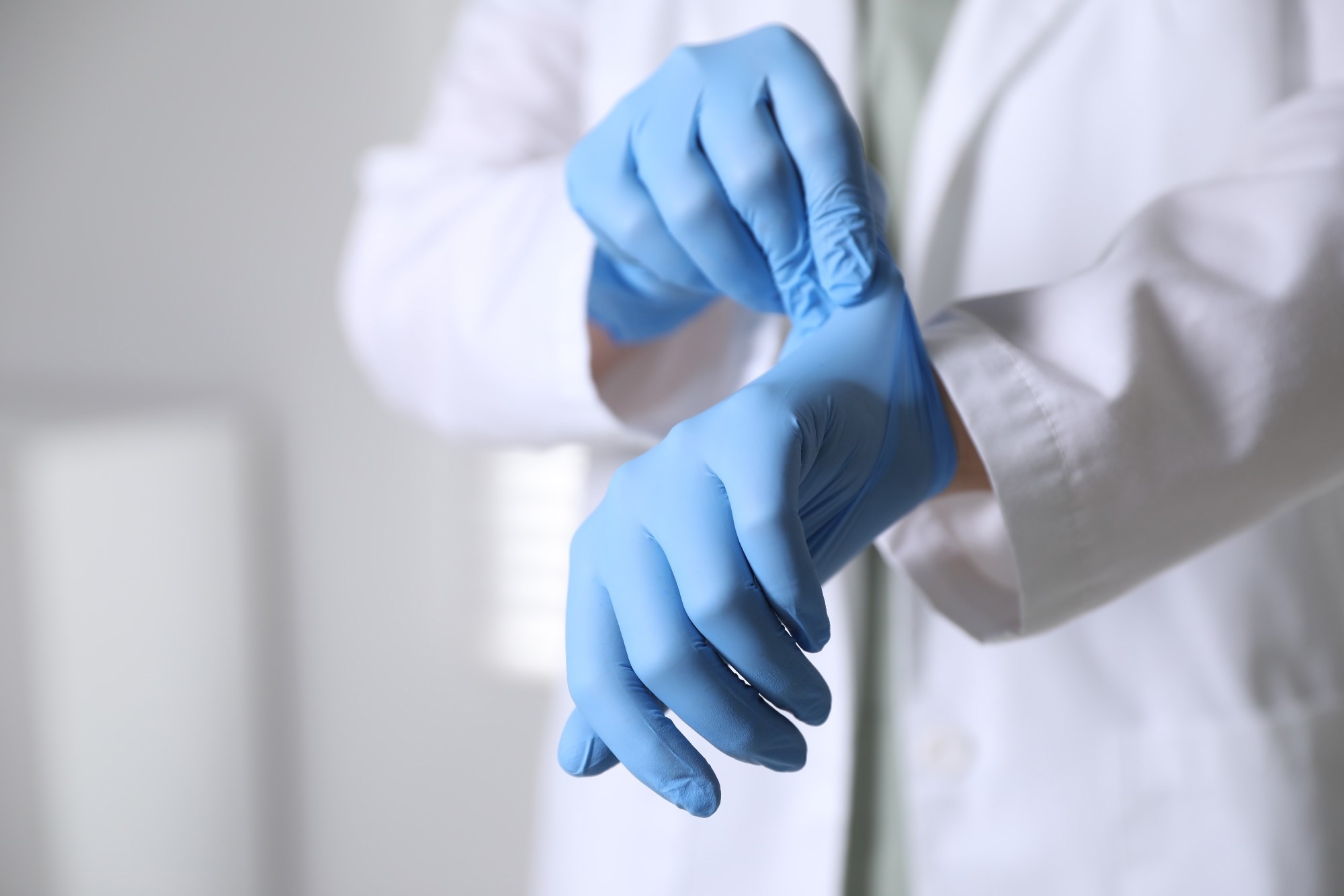 Medical worker putting on gloves in hospital