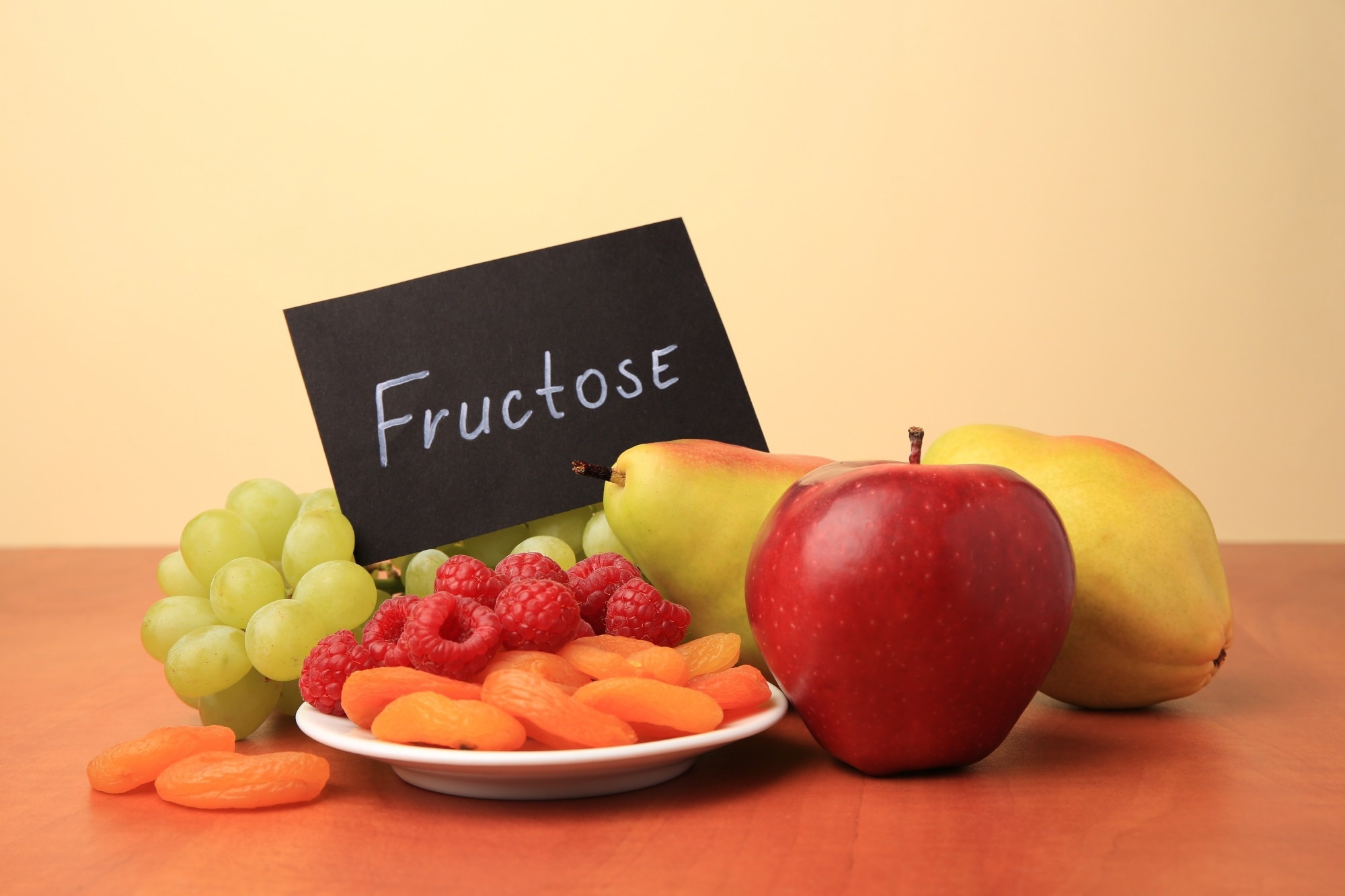 Card with the word fructose written on it placed onto of a fruit collection